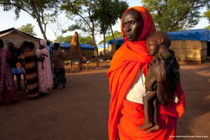 YIDA REFUGEE CAMP, SOUTH SUDAN - JUNE 29: A woman holds her grandson at a malnutrition and feeding center at the Yida refugee camp along the border with North Sudan June 29, 2012 in Yida, South Sudan. Yida refugee camp has swollen to nearly 60,000, as the refugees flee from South Kordofan in North Sudan. The rainy season has increased the numbers of sick children suffering from Diarrhea and severe malnutrition as the international aid community struggles to provide basic assistance to the growing population, most have arrived with only the clothes they are wearing. Many new arrivals walked from 5 days up to 2 weeks or more to reach the camp. (Photo by Paula Bronstein/Getty Images) ORG XMIT: 147399779